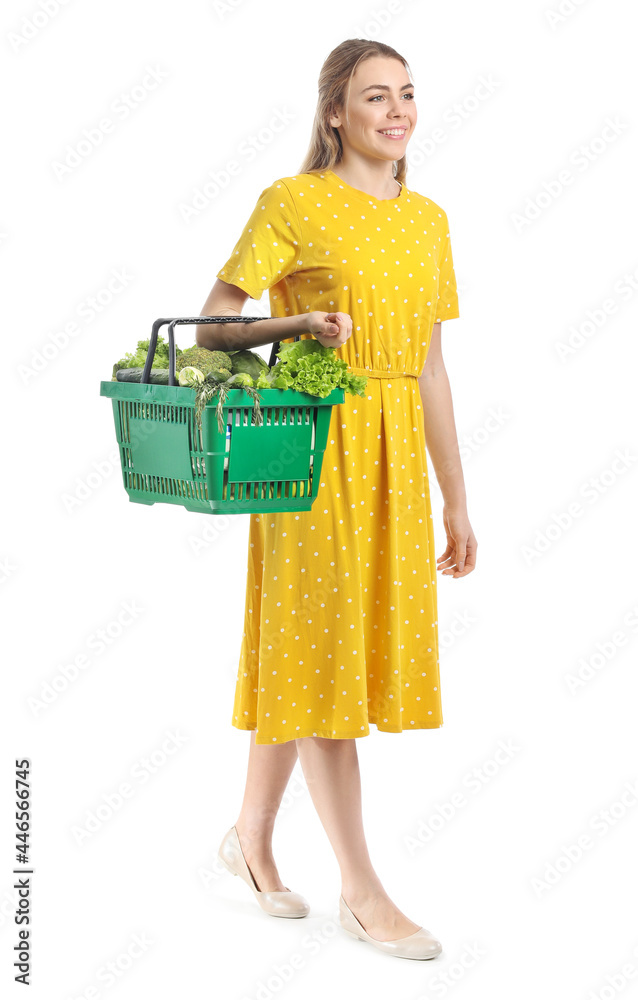 Young woman and shopping basket with fresh vegetables on white background