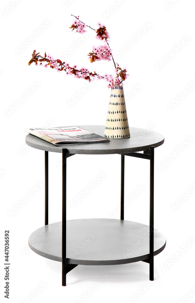 白色背景下，桌子上有盛开的树枝的花瓶