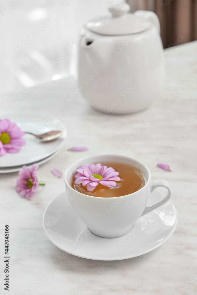 房间桌子上的一杯花茶、茶壶和鲜花