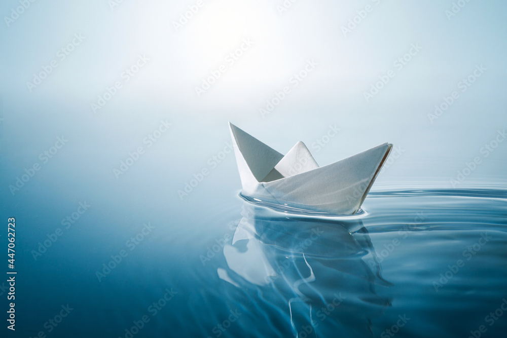 在蓝色无边的水面上航行的纸船。