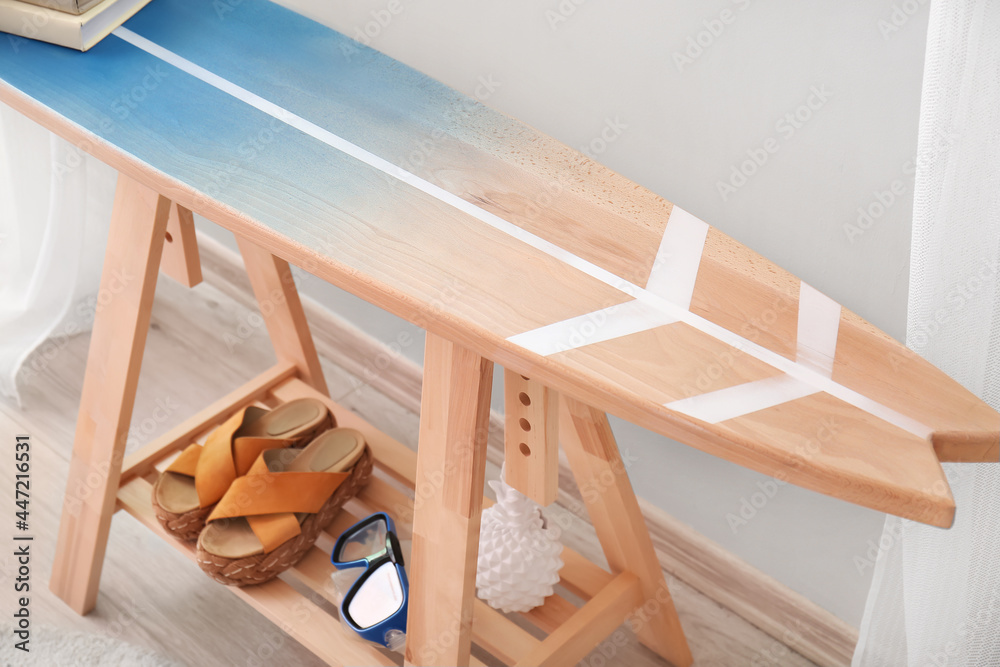 房间里有冲浪板和海滩配件的桌子