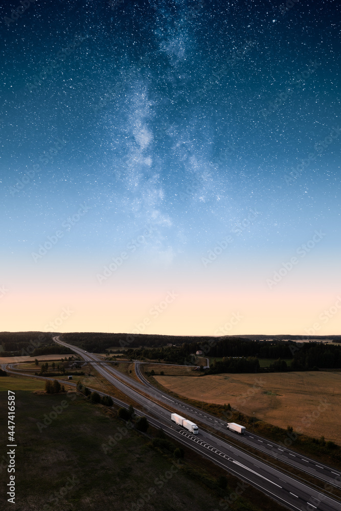 卡车行驶在高速公路上，有着史诗般的银河和星空。夜间运输和货物。