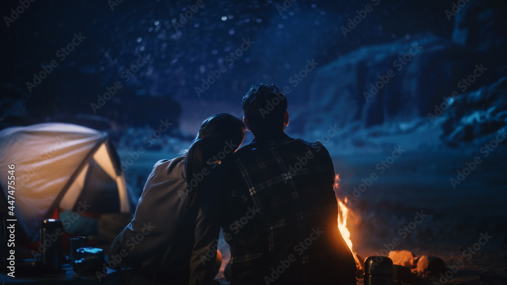快乐情侣在峡谷露营，坐在一起看篝火和星空，她让她休息