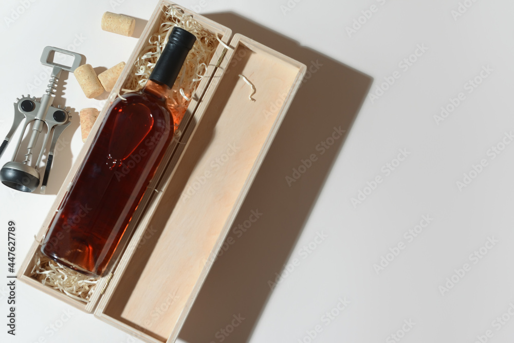 盒子里有一瓶精致的葡萄酒和开瓶器，背景为浅色