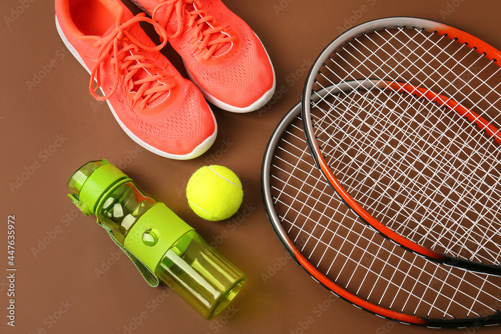 运动鞋、水瓶、网球拍和彩色背景球，特写