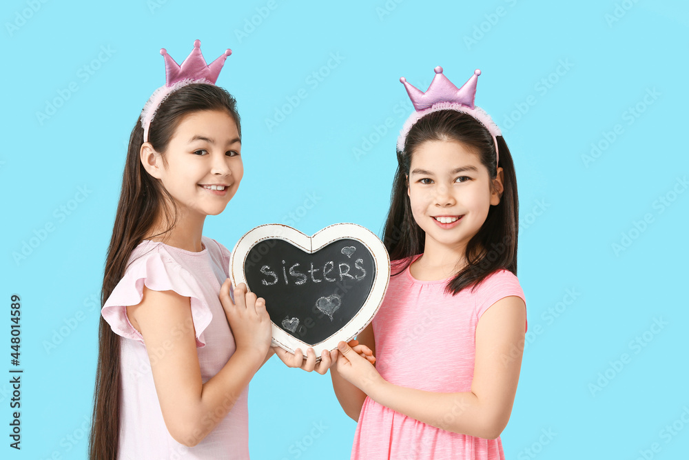 可爱的亚洲姐妹和板，颜色背景上有单词sisters