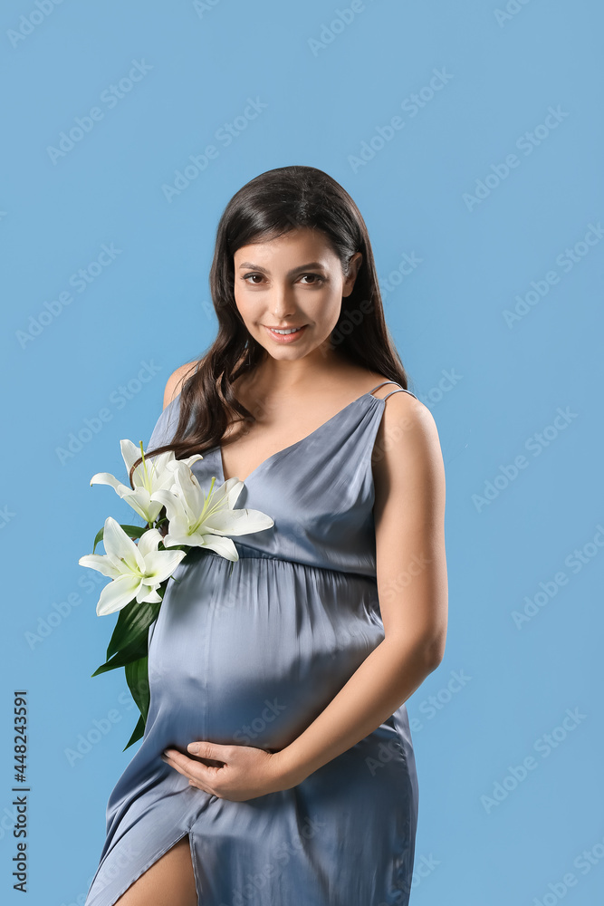 彩色背景上有百合花的年轻孕妇