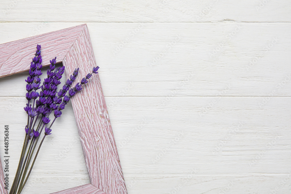 美丽的淡紫色花朵和浅色木质背景上的空相框