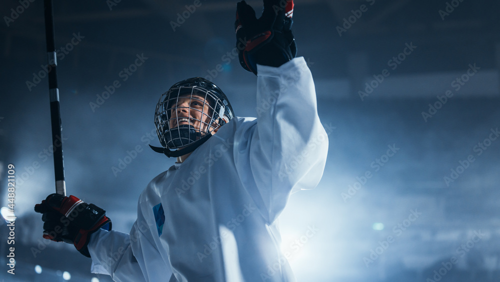 职业冰球运动员庆祝胜利，举起双臂。