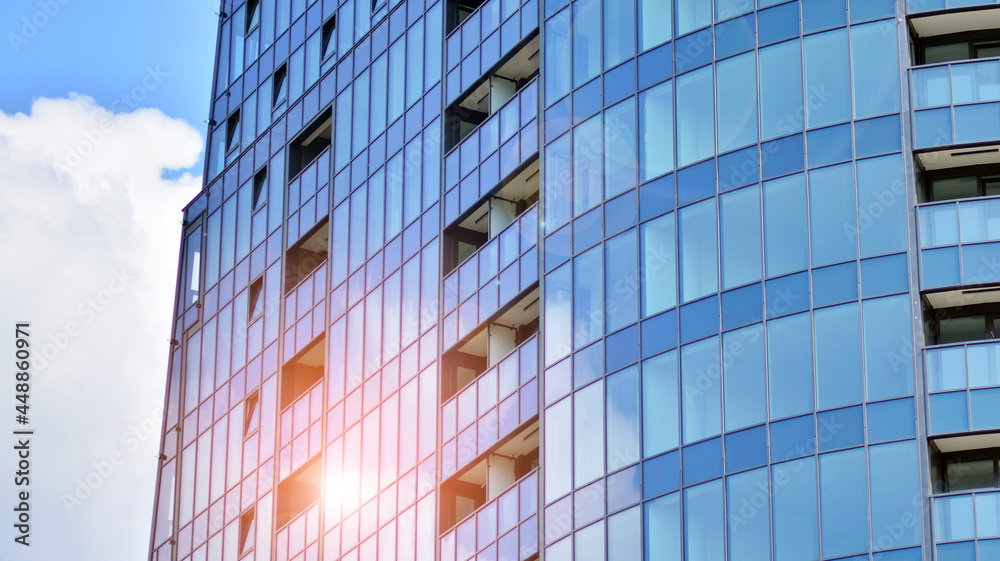 玻璃和钢。现代办公楼的镜面立面，阳光眩光反射