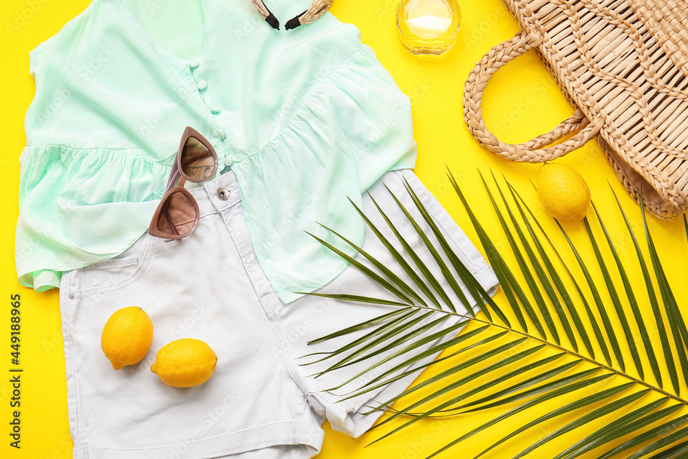 以女性服装、配饰、柠檬和棕榈叶为背景的构图，特写