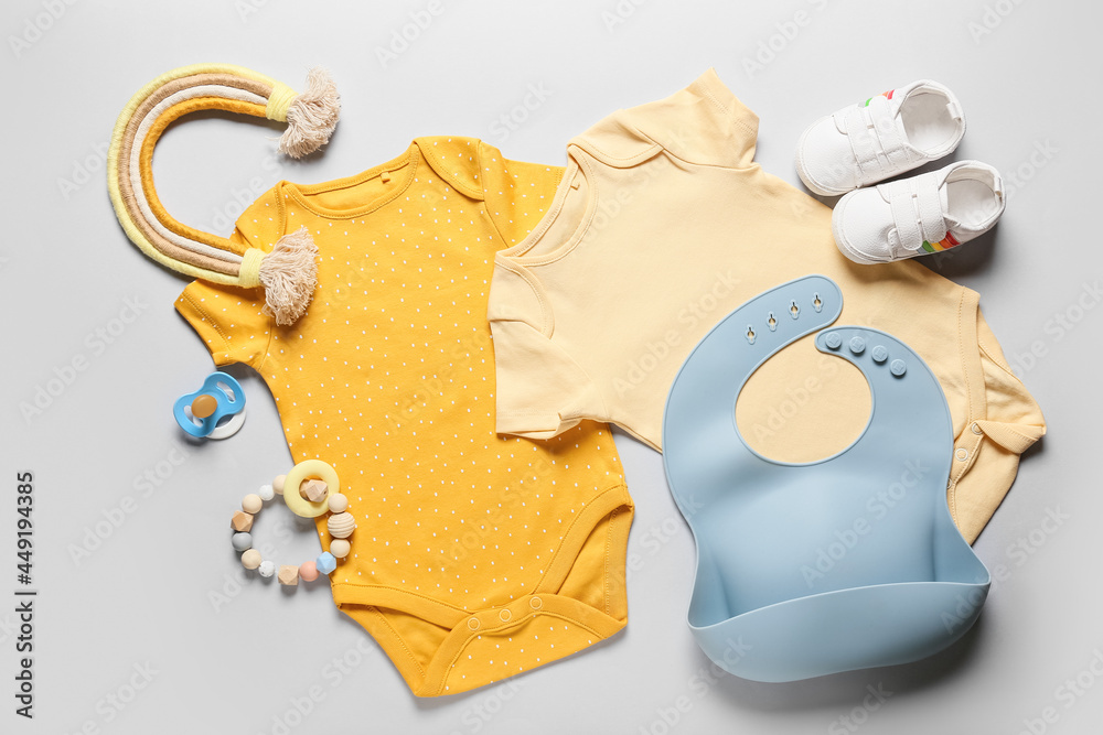 浅色背景下的婴儿衣服、鞋子、玩具和配件