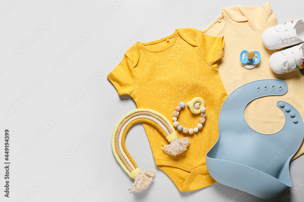 浅色背景下的婴儿衣服、鞋子、玩具和配件