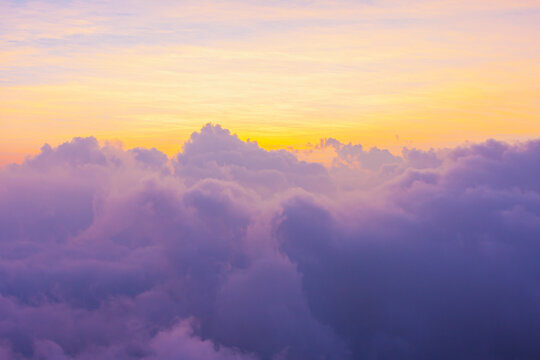 日出或日落时，太阳发出美丽的金色阳光，山顶上有柔软的紫色云