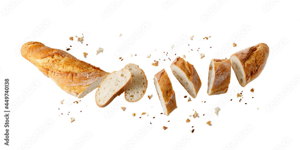 切新鲜的烤面包小麦法棍面包，面包屑和种子在白色上孤立飞行