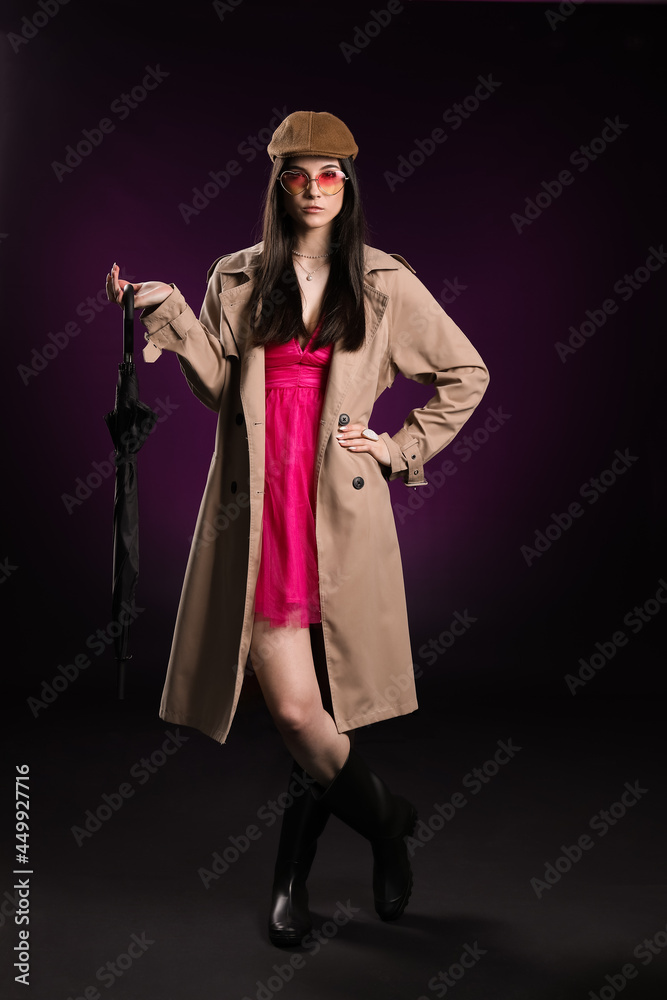 Stylish young woman with umbrella on dark background