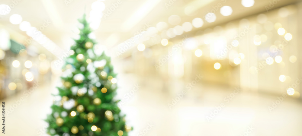 Defocused Christmas background. Beautiful decorated Christmas tree in light spacious shopping mall h