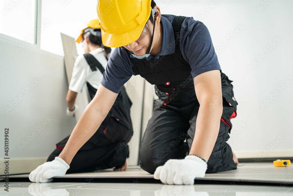 亚洲工匠工人在家里的地板上安装强化木地板