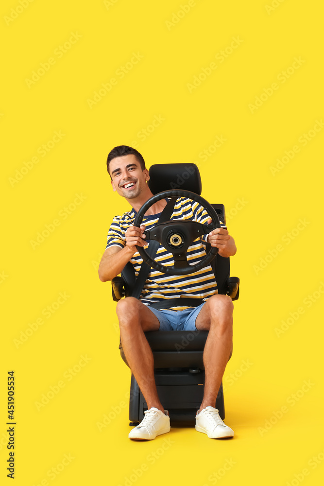 男子坐在汽车座椅上，方向盘为彩色背景