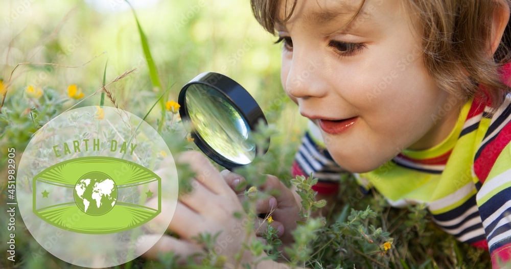 在大自然中使用放大镜在男孩身上合成绿色地球仪标志和地球日文字