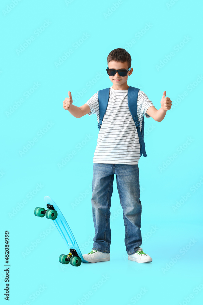 带滑板的小男生在彩色背景上竖起大拇指