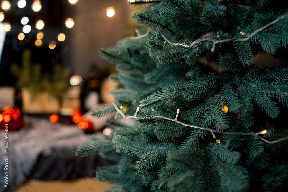 圣诞背景上有球和节日灯光的冷杉树枝，闪闪发光。裁剪视图