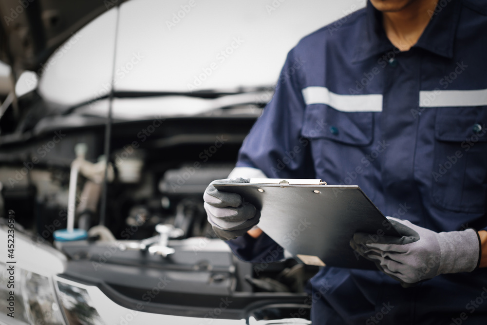 Hand of car mechanic with wrench. Auto repair garage. mechanic works on the engine of the car in the