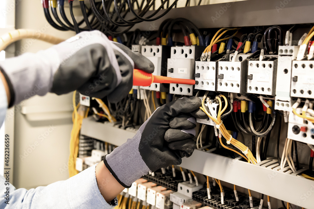 电工在控制中连接系统、配电盘和电气系统中的电线