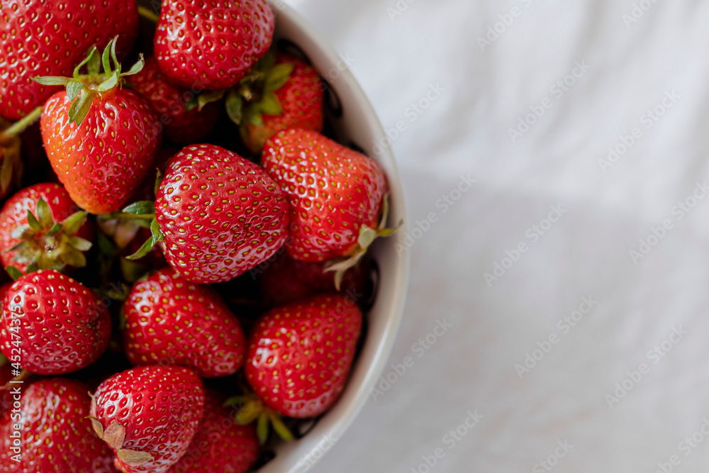 新鲜收获的草莓放在一个白色的碗里