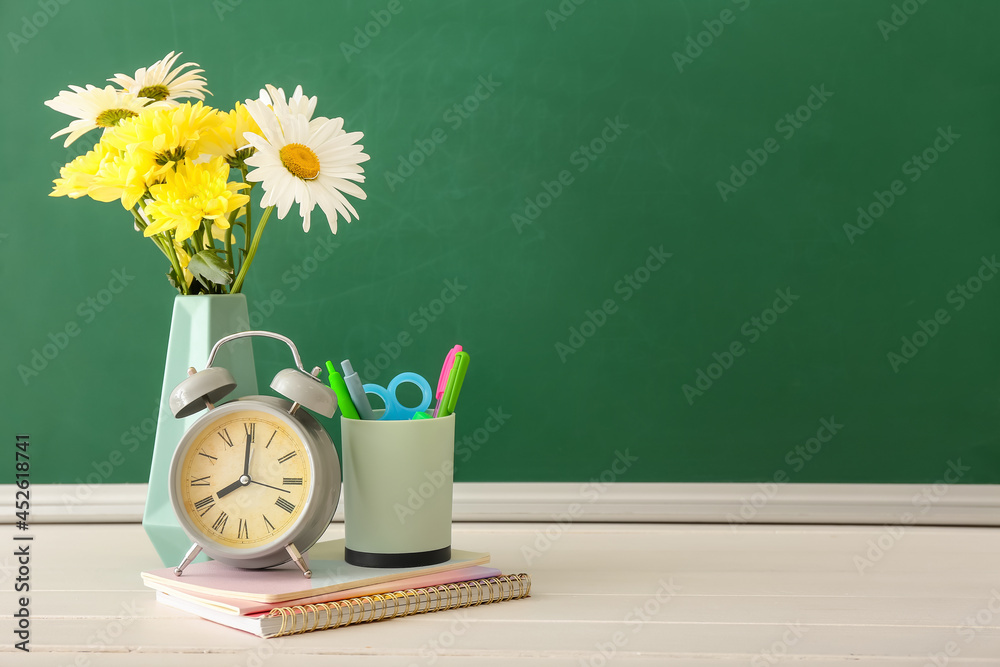 教室桌子上放着鲜花和文具的花瓶。教师节庆祝活动