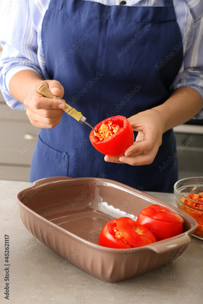 女人在厨房的桌子上准备塞满的西红柿，特写镜头