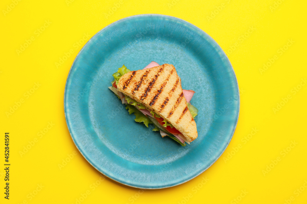 Plate with tasty sandwich on color background