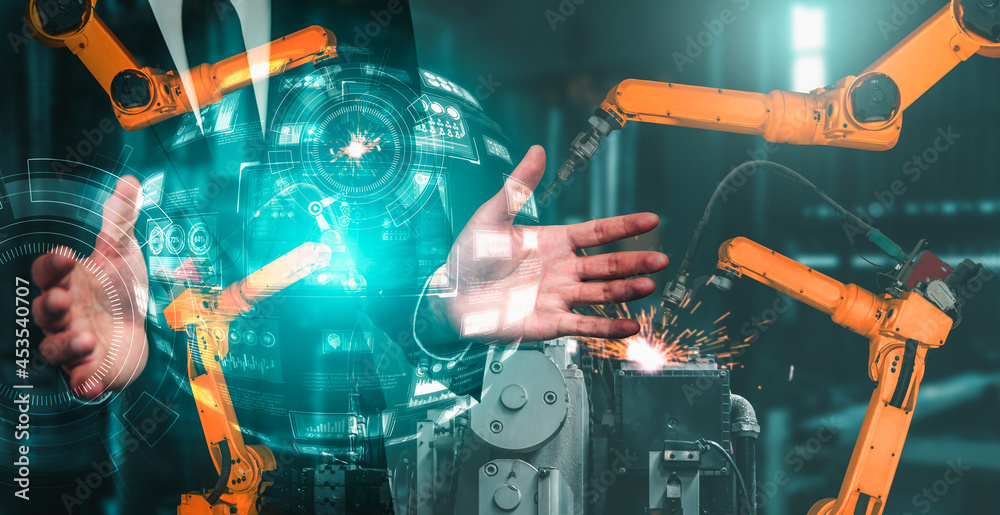 机械化工业机械臂和工厂工人双重曝光。机器人技术的概念