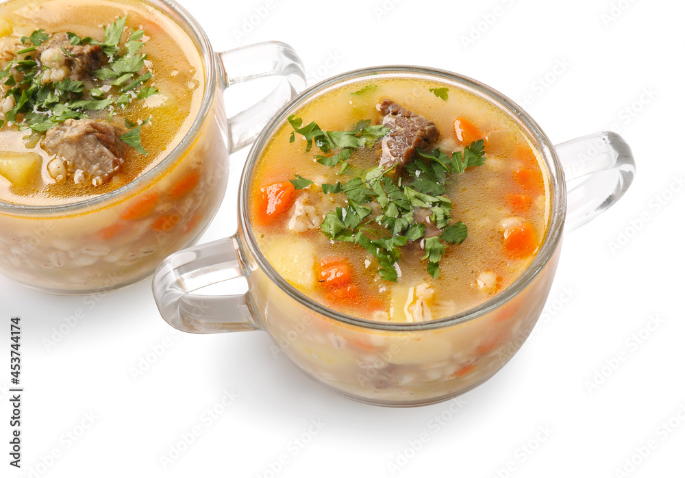 Bowls with tasty beef barley soup on white background
