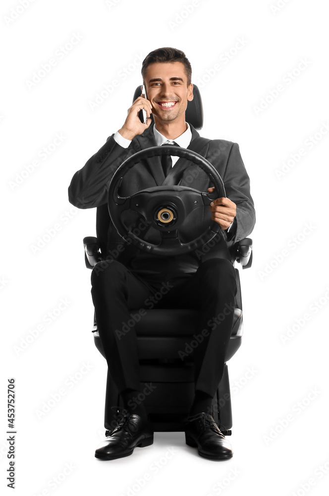 坐在汽车座椅上、拿着方向盘的商人在白底上打电话