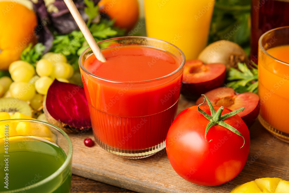 彩色木质背景上的健康果汁、水果和蔬菜玻璃杯，特写