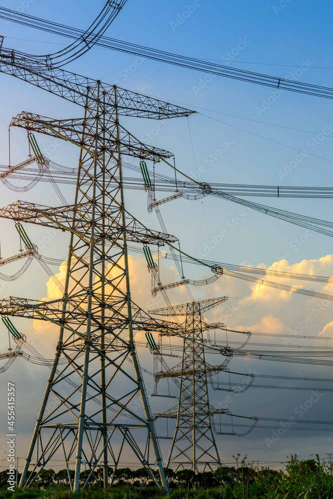 朝阳下的高压输电塔产业景观，城市输电线路。