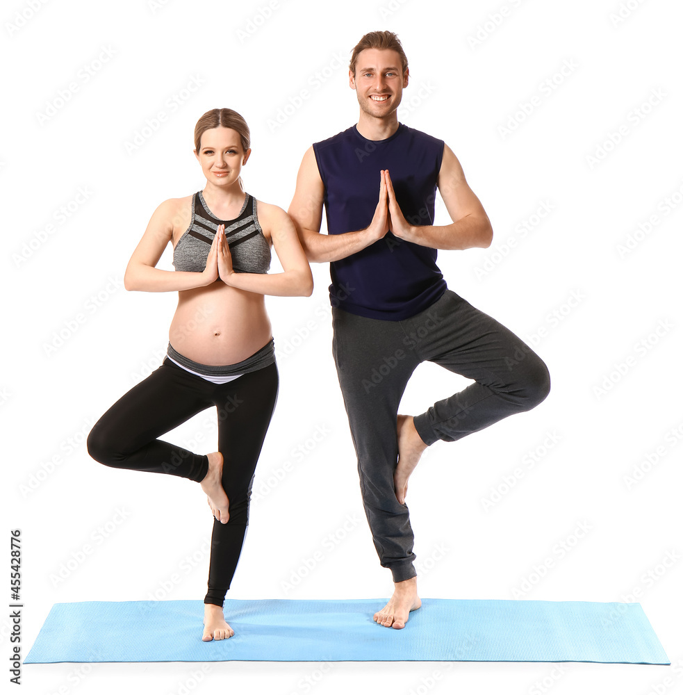 年轻孕妇和丈夫在白色背景下练习瑜伽