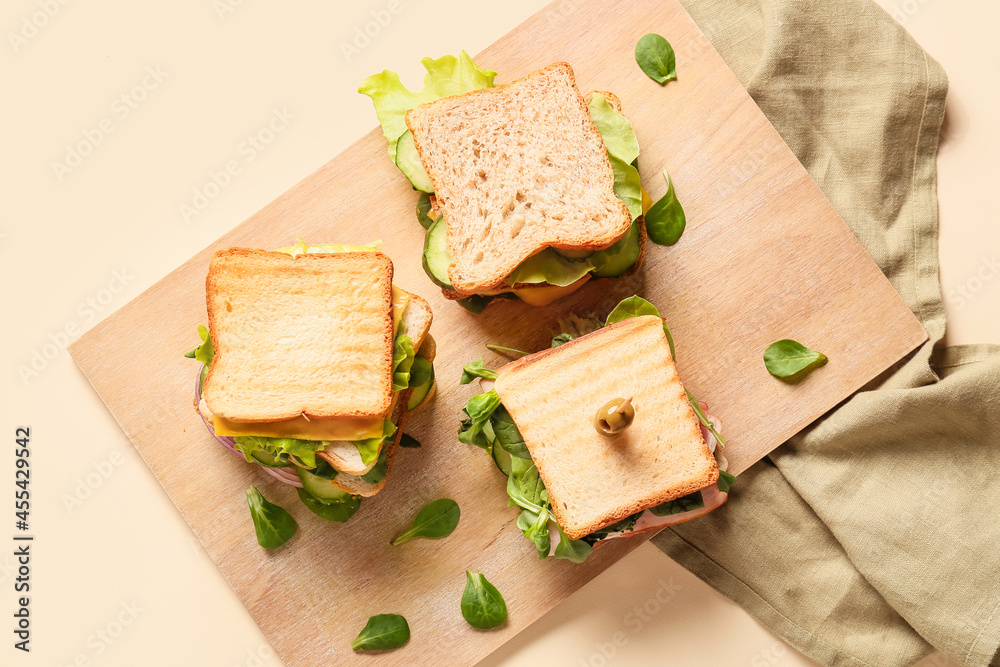 彩色背景上有美味三明治的木板