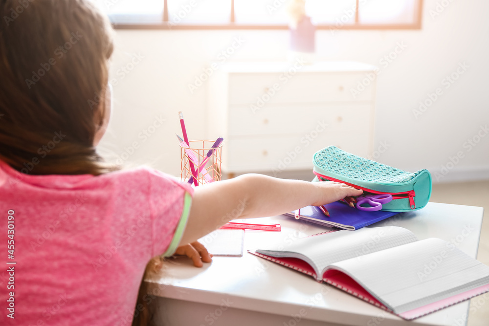 Little girl with pencil case at home
