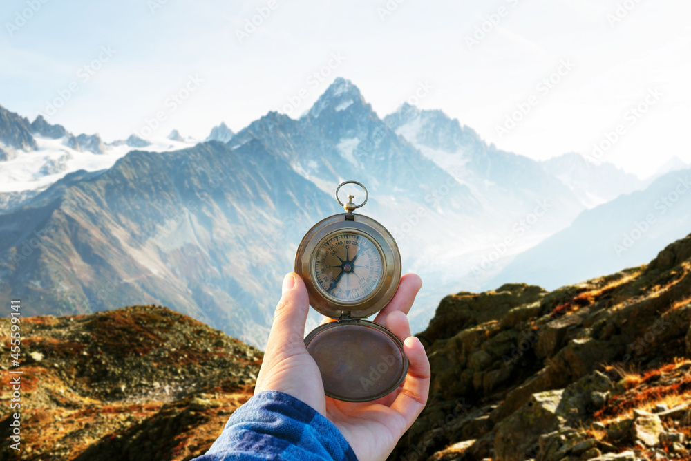 Monte Bianco mountains range and tourist hand with old metal compass on a foreground. Vallon de Bera