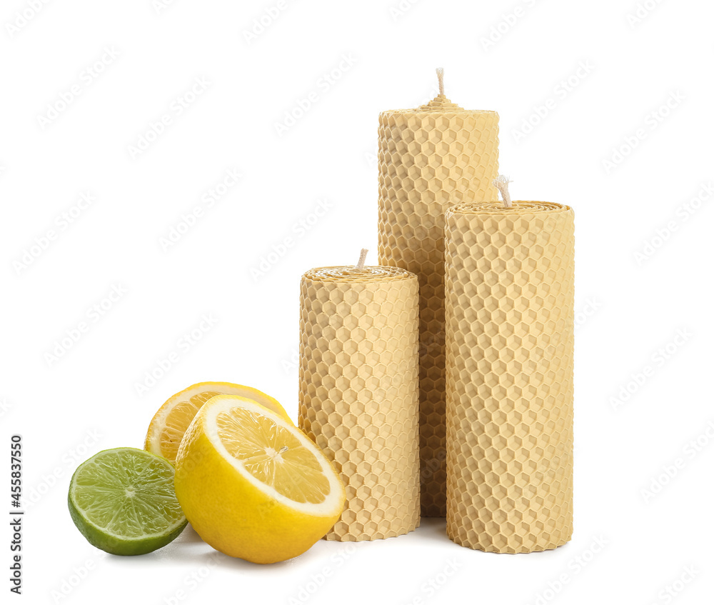 白色背景上的蜡蜡烛和切片柑橘类水果
