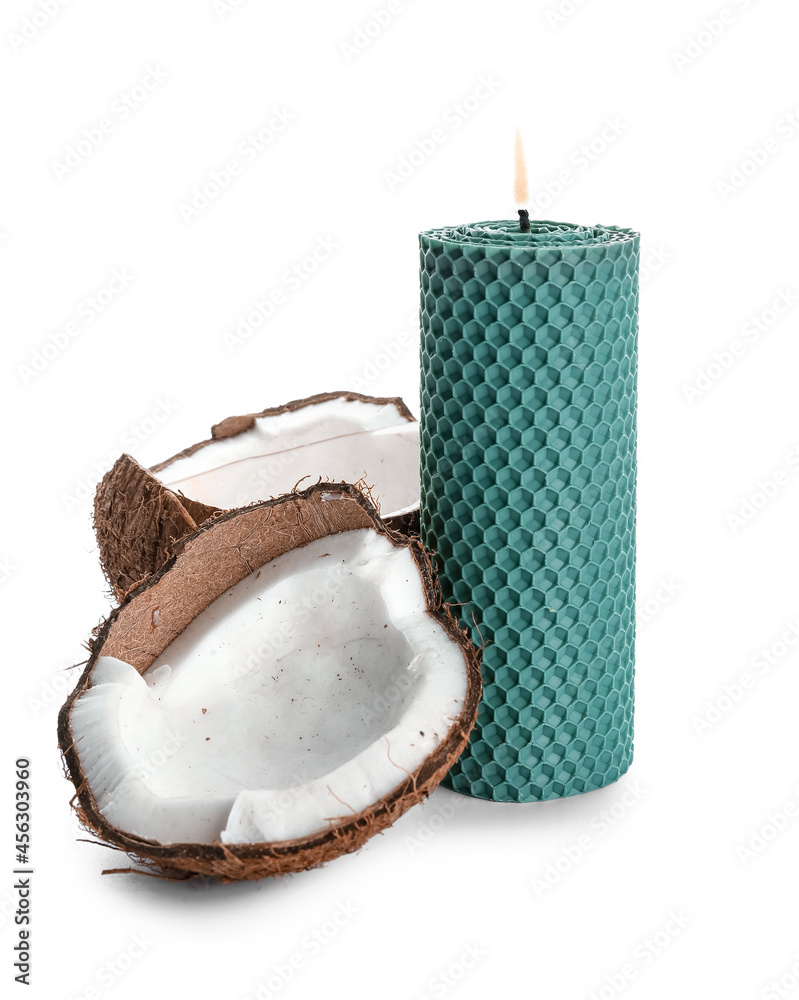 白色背景下燃烧的蜡烛和破裂的椰子