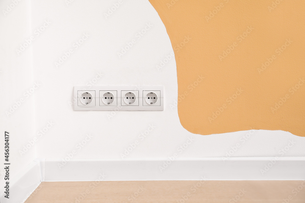 彩色墙上带插头的电气插座