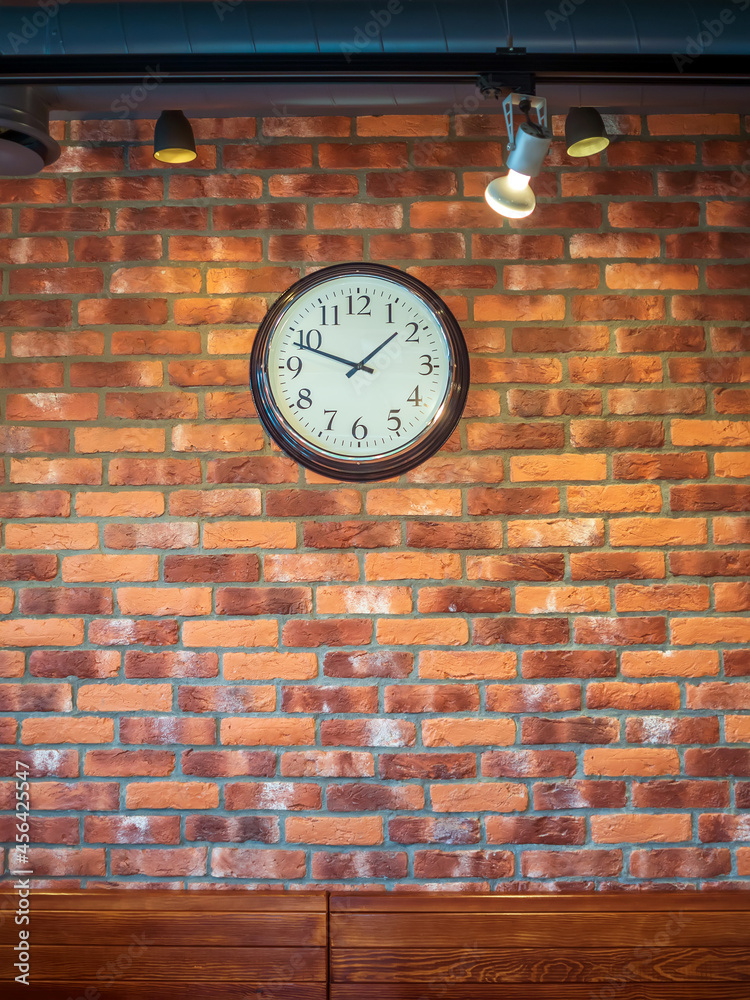 挂钟挂在红砖墙上。