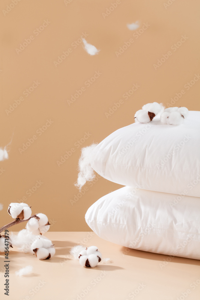 棕色背景的白色棉质花朵和枕头。