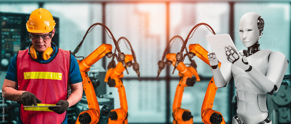机械化工业机器人和人类工人在未来工厂合作。人工的概念