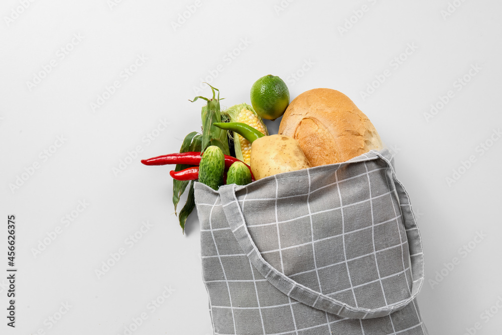 白色背景上有不同蔬菜和面包的环保袋