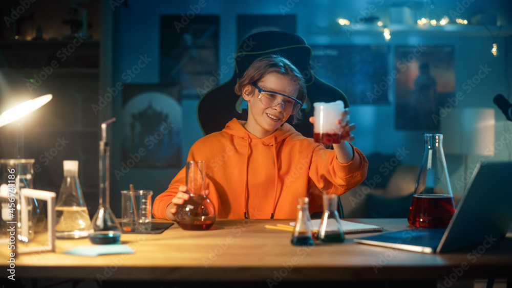 戴着安全眼镜的聪明男孩在家里把烧杯里的化学品混合在一起。青少年正在接受教育