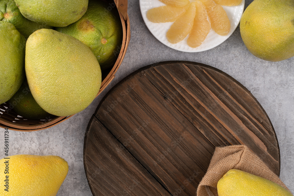 Fresh pomelo fruit on gray cement table background.